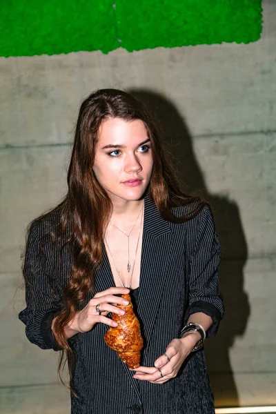 Retrato de menina em blazer segurando croissant — Fotografia de Stock