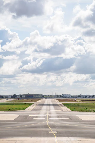 Empty airport runway with markings in cloudy day