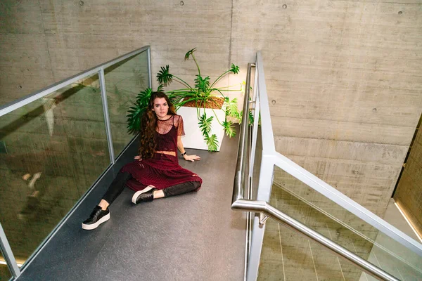 Молодая женщина сидит с раздвинутыми ногами рядом с растением — стоковое фото