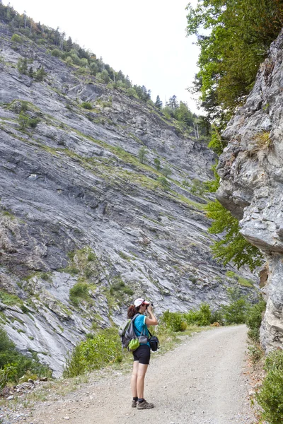 Menina fotógrafa fazendo uma foto no caminho de uma caminhada — Fotografia de Stock