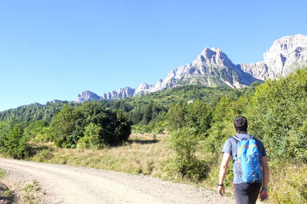 Guy wandelen in een pad met bomen en bergen omringd in de Pyreneeën — Stockfoto
