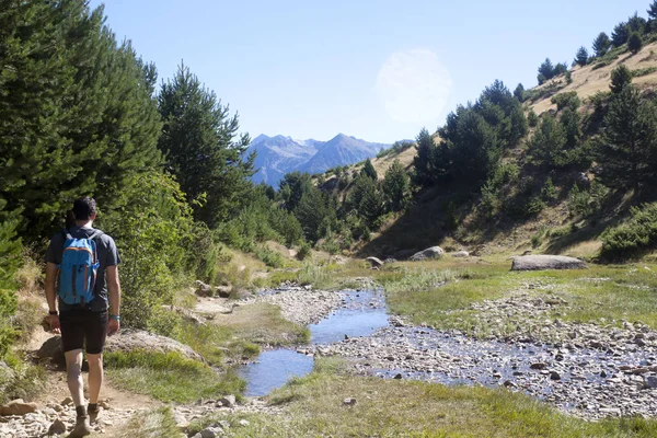 Bergbeklimmer wandelen in de bergen met een stoom dicht bij hem in de Pyreneeën, Spanje — Stockfoto