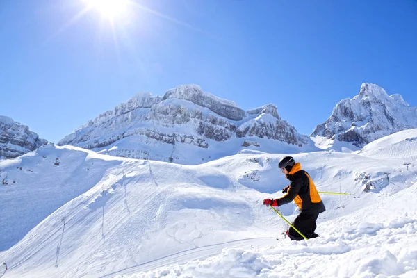 Σκιέρ στη μέση των βουνών σκι κάτω από το λόφο με τον ήλιο — Φωτογραφία Αρχείου