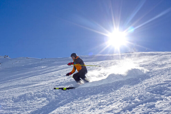 skier speeding in a sunny day making powder up