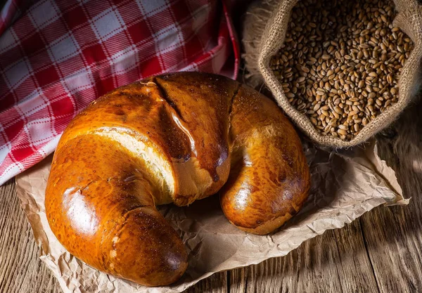 Eski ahşap masa üzerinde lezzetli tereyağı kruvasan. — Stok fotoğraf