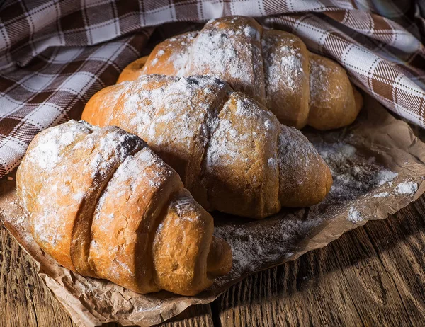Köstliche frische Croissants auf einem hölzernen Hintergrund — Stockfoto