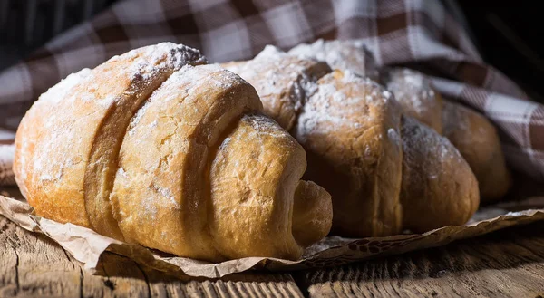 Köstliche frische Croissants auf einem hölzernen Hintergrund — Stockfoto