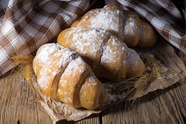 Köstliche frische Croissants auf einem hölzernen Hintergrund — Stockfoto