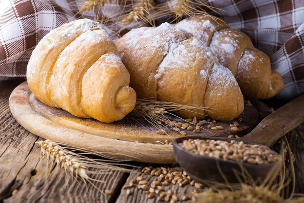 Köstliche frische Croissants auf einem hölzernen Hintergrund — Stockfoto