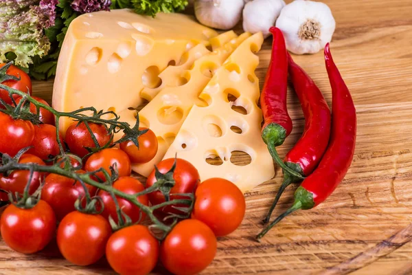 Formaggio con verdure fresche su uno sfondo di legno — Foto Stock