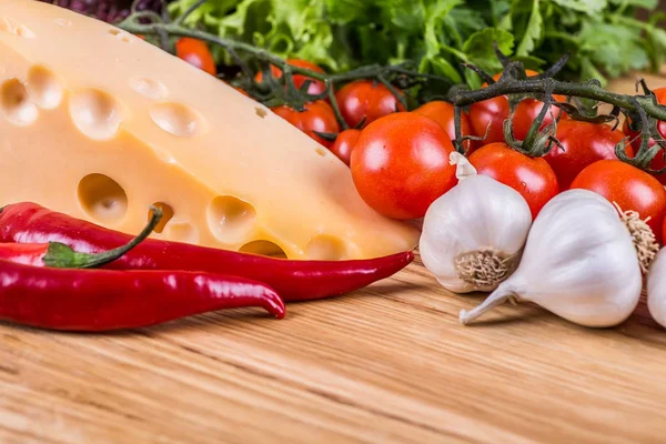 Käse mit frischem Gemüse auf einem hölzernen Hintergrund — Stockfoto