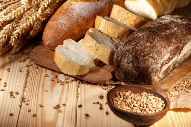 Ahşap masa arkasında pişmiş ekmek çeşitleri