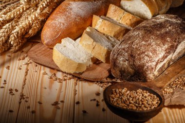 Ahşap masa arkasında pişmiş ekmek çeşitleri