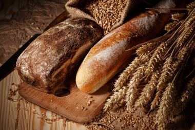 Ahşap masa arkasında pişmiş ekmek çeşitleri