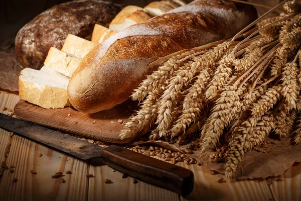 Ahşap masa arkasında pişmiş ekmek çeşitleri