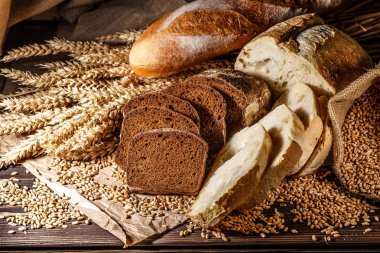 Ahşap masa arkasında pişmiş ekmek çeşitleri