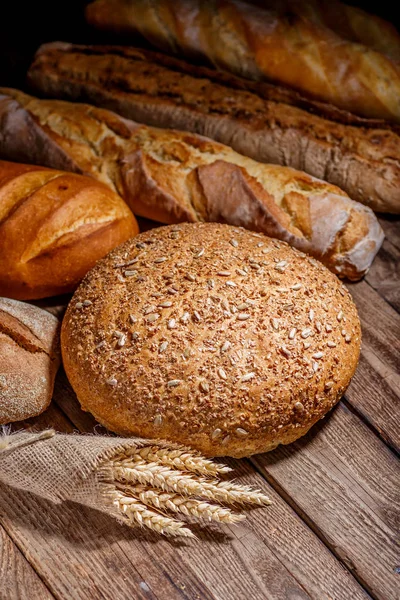 Auswahl an gebackenem Brot auf Holztischhintergrund — Stockfoto