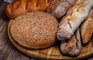 Ahşap masa arkasında pişmiş ekmek çeşitleri