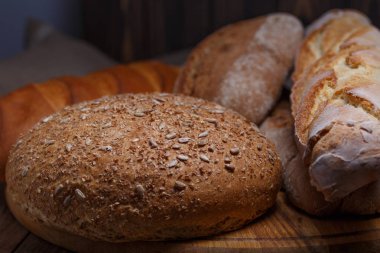 Ahşap masa arkasında pişmiş ekmek çeşitleri
