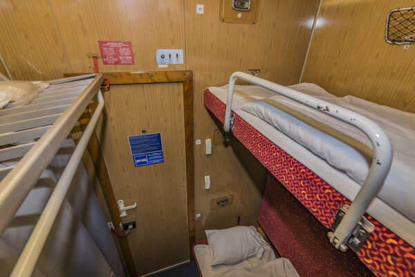Interior of night train with beds and wash basin