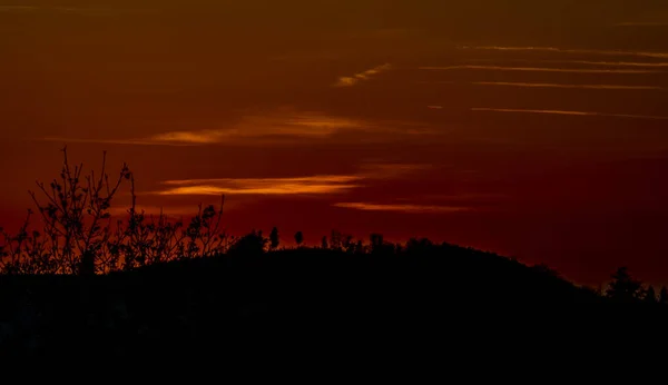 Κόκκινο πορτοκαλί ηλιοβασίλεμα με λόφους το φθινόπωρο σκοτεινό βράδυ — Φωτογραφία Αρχείου