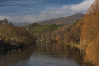 Perstejn köyündeki Ohre nehri mavi gökyüzü, renkli ormanlar ve dağlarla