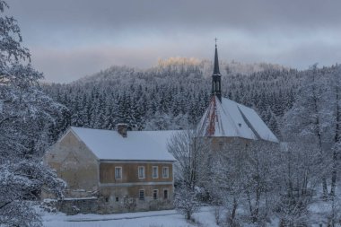 Loucovice köyünde sisli ve kiliseli mavi bulutlu bir sabah