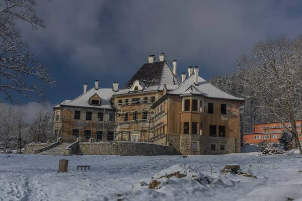 Duży dom w odbudowie w słoneczny, śnieżny dzień — Zdjęcie stockowe