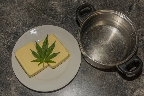 Wykonanie masła marihuanowego z liśćmi i żółtym masłem, które będzie zielone — Zdjęcie stockowe