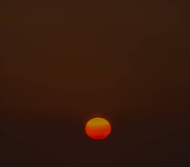 Dark sunrise with orange small sun with fog in north Bohemia