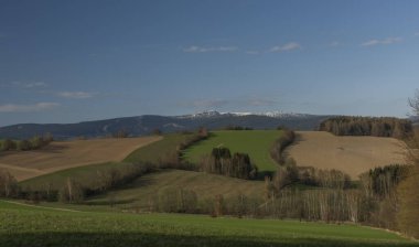 Krkonose dağları ilkbaharda güneşli bir günde taze çayırlar ve çayırlarla renklendirilir.