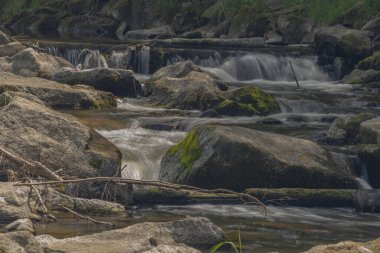 Beskdy dağlarında güneşli bahar ışığı altında büyük taşlarla Becva nehri.