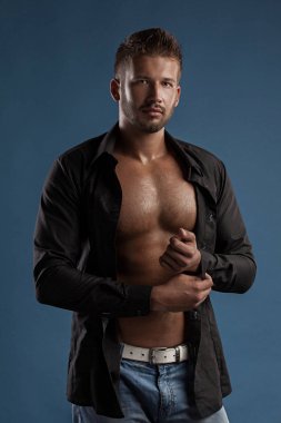 Model adam göğüslü karanlık bir arka plan bir gencin Jeans kas vücut üzerinde açık. Bir stüdyoda vurdu .