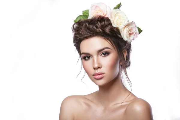Belleza chica joven, piel limpia, hermoso maquillaje, trenzas de peinado y flores de rosas en el pelo . — Foto de Stock