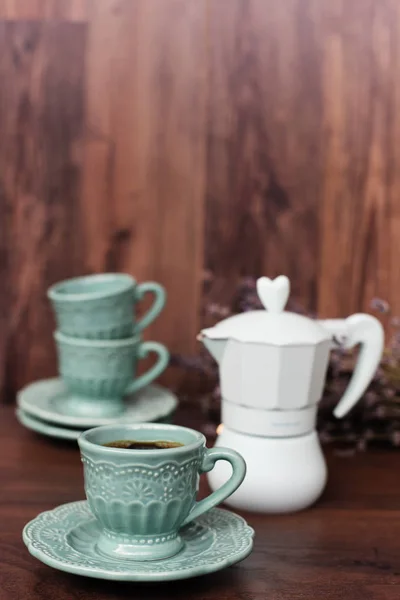 Tasse Kaffee und italienische Kaffeemaschine in blau, Lavendelduft. dunkler Holzhintergrund — Stockfoto