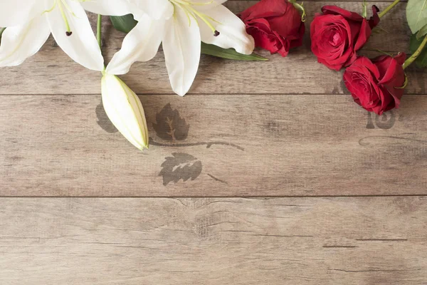 Marco floral con impresionantes lirios blancos y rosas rojas sobre fondo de madera. Copiar espacio. Boda, tarjeta de regalo, día de San Valentín o fondo del día de la madre — Foto de Stock