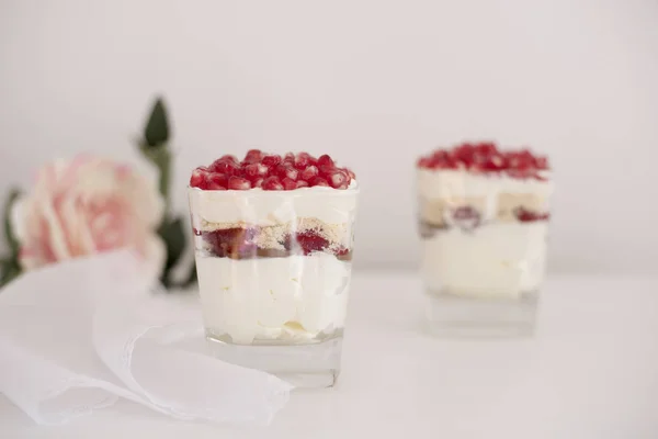 Hemmagjord skiktad dessert med mascarpone, choklad, grädde, färska jordgubbar, kakor, granatäpple. Ost i ett glas. Vit bakgrund, hög nyckel, selektivt fokus — Stockfoto