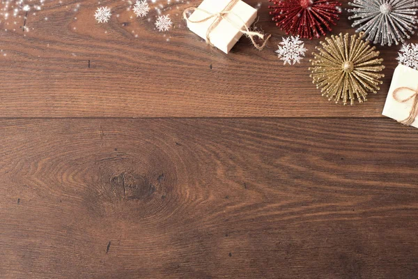 Χριστουγεννιάτικο φόντο με διακοσμήσεις και κουτιά δώρου σε ξύλινη σανίδα. Με φόντο μπλε sparkly διακοπών με αντίγραφο χώρο. Θέμα Χριστουγέννων με δώρα και ελεύθερο χώρο για το κείμενο — Φωτογραφία Αρχείου