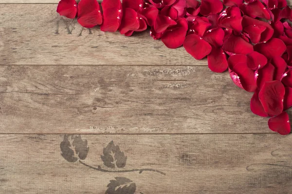 Pétalos de rosa roja en el fondo de madera. Pétalos de rosa Frontera sobre una mesa de madera. Vista superior, espacio de copia. Marco floral. Fotografía de marketing con estilo. Boda, tarjeta de regalo, día de San Valentín o día de las madres bac — Foto de Stock