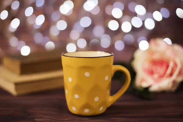 Kaffeetasse, Tee, alte Bücher und Rose auf einem Holztisch im Café mit Bokeh-Licht Hintergrund. Freizeit Lifestylekonzept. Nachts Kaffee auf dem Tisch. rustikaler Hintergrund mit schönen Weihnachtslichtern aus Bok — Stockfoto