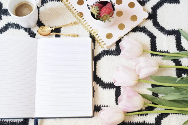 Café, fresas, cuadernos en alfombra escandinava. Tulipanes rosados y cucharas de oro. Patrón blanco negro y tema de oro. Concepto de estilo de vida. Copiar espacio —  Fotos de Stock