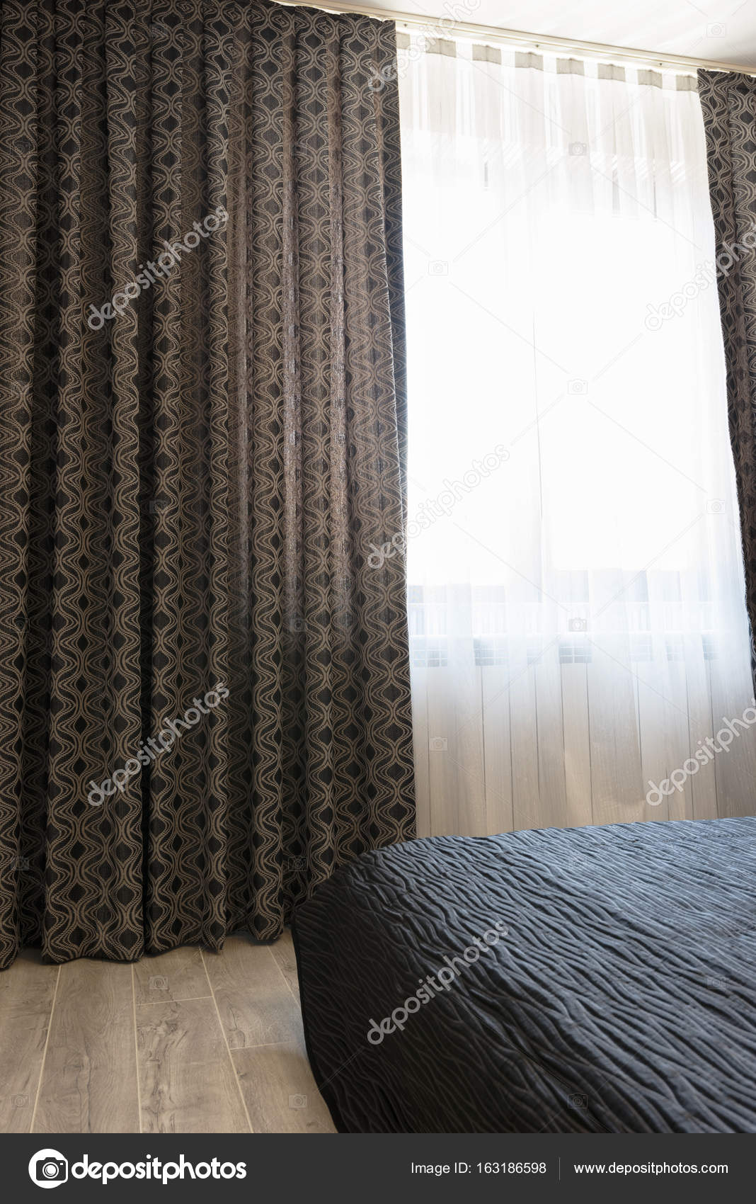 Lange donkere luxe gordijnen en gordijnen van tulle, rieten op een ... Lange donkere luxe gordijnen en gordijnen van tulle, rieten op een ...