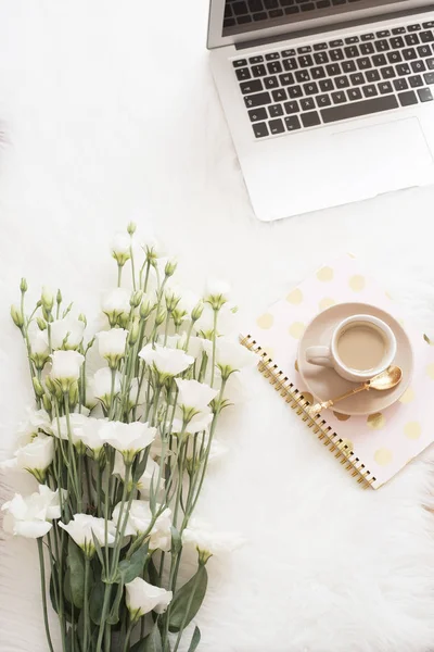 Dizüstü bilgisayar, dizüstü bilgisayar ve beyaz bir yerde bir büyük buketi beyaz çiçekler kahve halı kürk. Serbest moda rahat kadınlık ev çalışma alanı düz yatıyordu tarzı. Üstten Görünüm, pembe ve altın