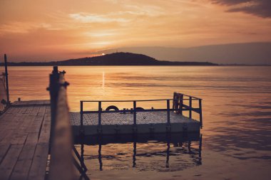 Plaj ve deniz kenarında güzel gün batımı ahşap köprüde. Filtre eklendi