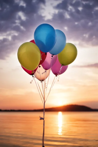 Kolorowe balony na moście w morze i piękny zachód słońca. Urodziny Party balony — Zdjęcie stockowe