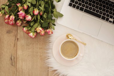 Kadınsı işyeri kavramı. Dizüstü bilgisayar, çiçek gül ile serbest çalışma alanı. Blogger çalışma.