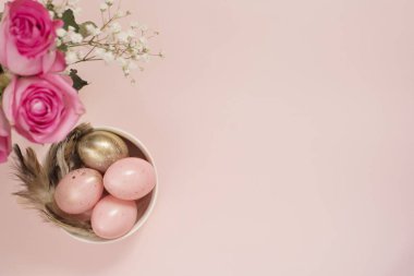 Pembe ve altın yumurta. Yumurta, çiçek ve tüyler pastel Paskalya kavramı. Punchy pastel