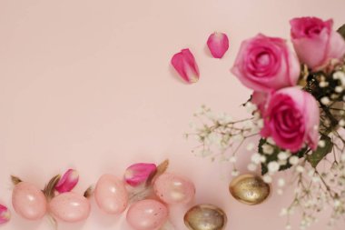 Pembe ve altın yumurta. Yumurta, çiçek ve tüyler pastel Paskalya kavramı. Punchy pastel. Kopya alanı