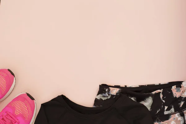 Жіночі рожеві кросівки, спортивне взуття, легінси та спортивні блузки в стилі плоского ліжка, вид зверху. Фітнес-концепція, активний спосіб життя, концепція догляду за тілом — стокове фото