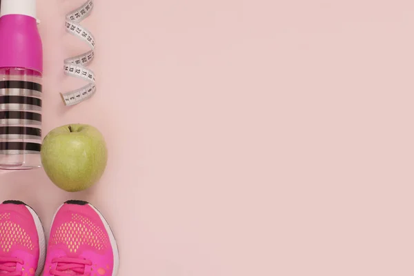 Kvinnliga rosa sneakers, sport skor, flaska vatten, grönt äpple och mätaren i platt lekmanna stil, ovanifrån. Fitness-konceptet, aktiv livsstil, kropp vård koncept. Kopiera utrymme — Stockfoto